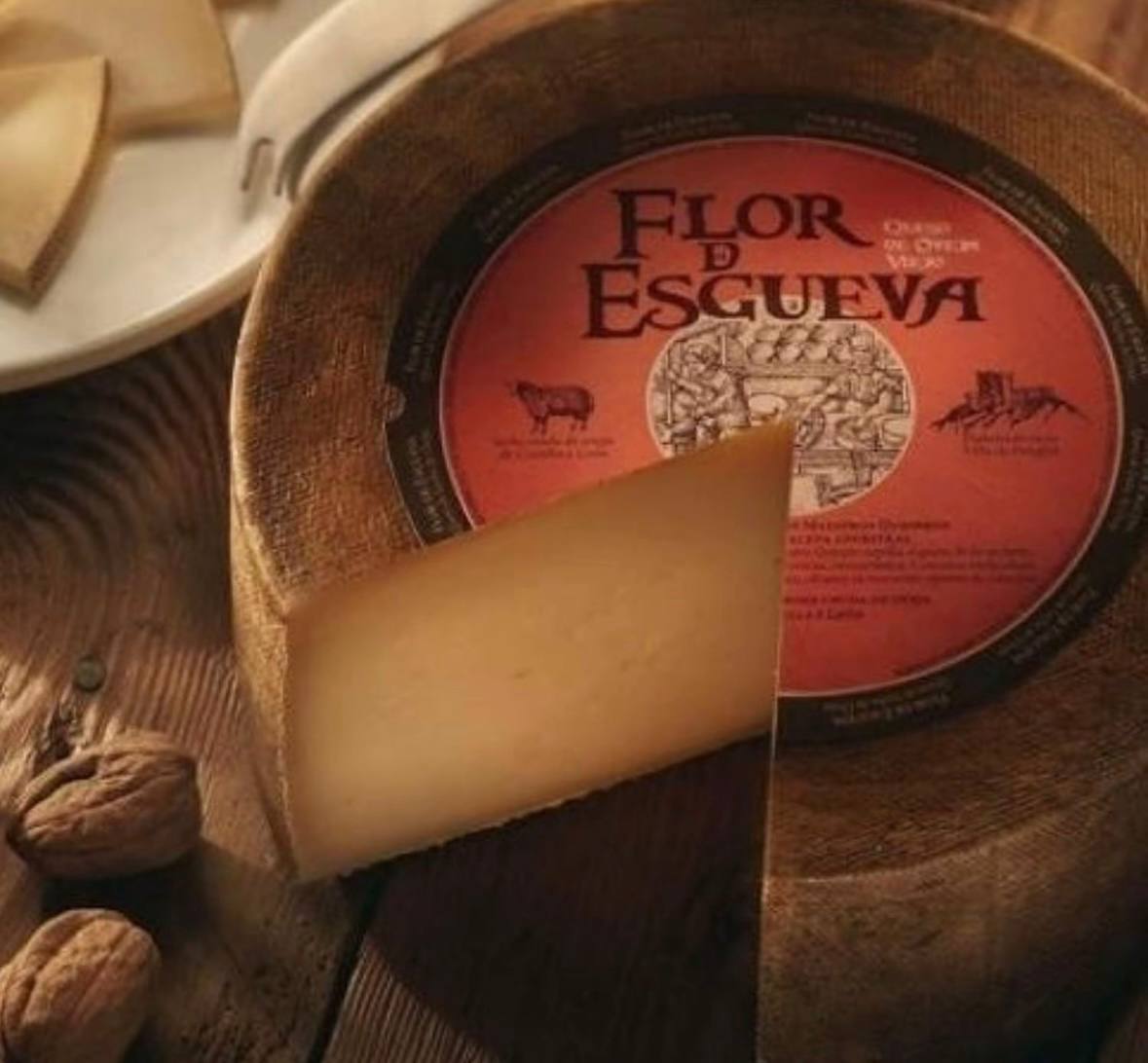 Cuña de queso de oveja viejo Flor de Esgueva sobre tabla de madera con nueces
